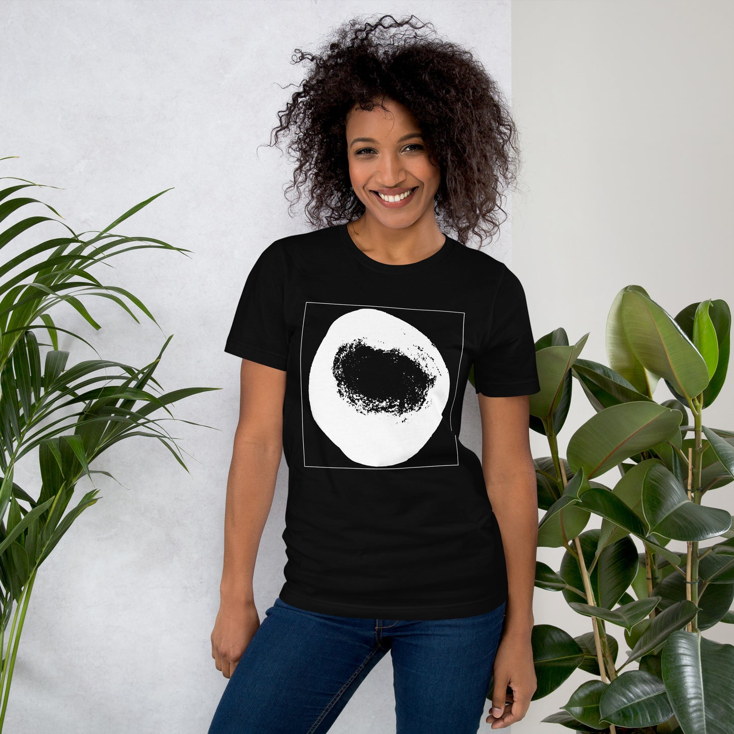 Woman wearing a black cotton graphic t-shirt with white abstract dome artwork in a thin white square on front