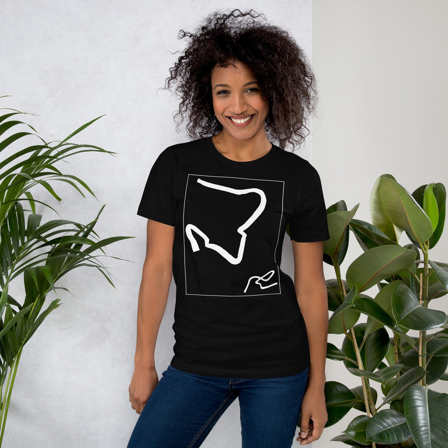 Woman wearing a black cotton graphic t-shirt with white abstract artwork of lines resembling a paperclip on front