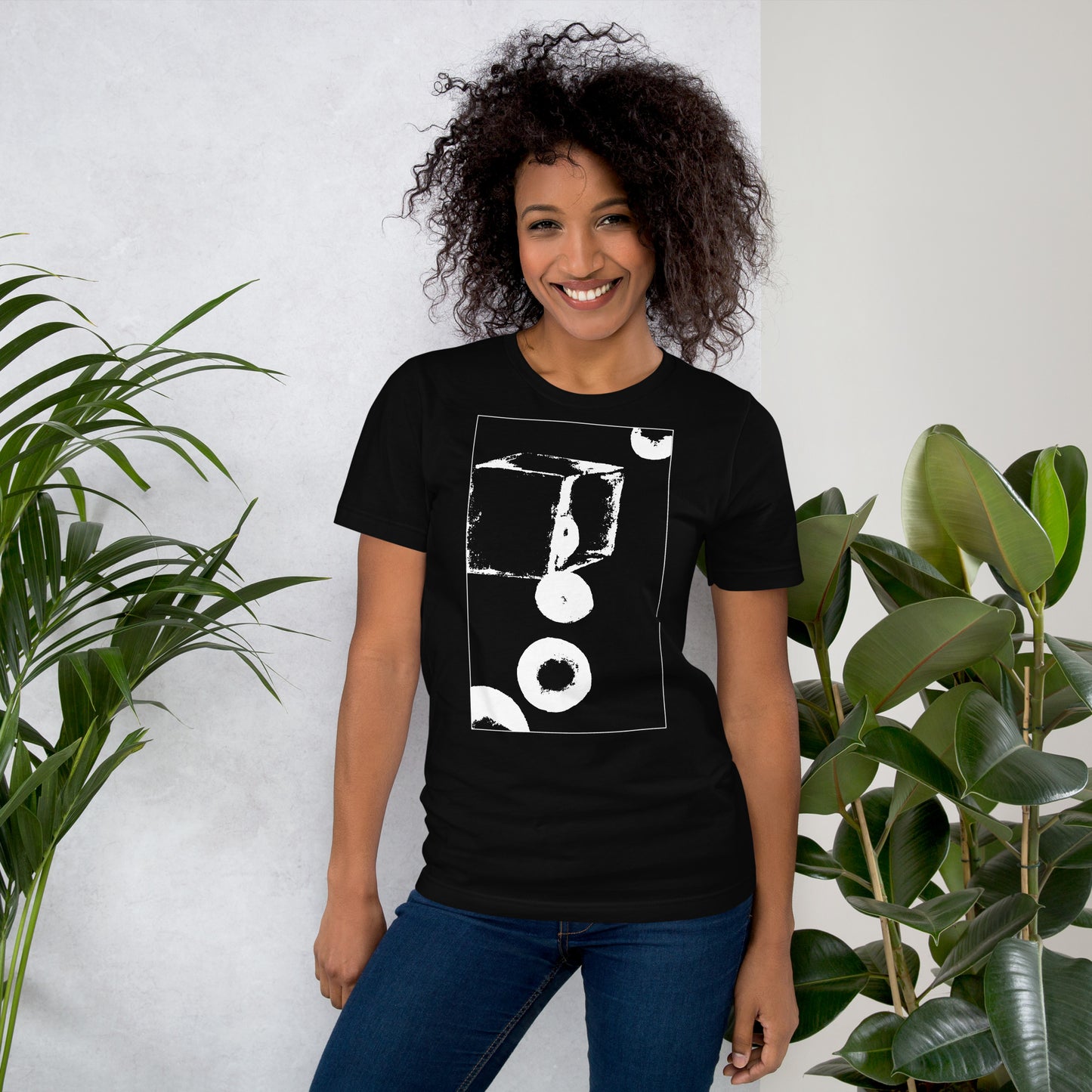 Woman wearing black cotton graphic t-shirt with white abstract cube and spheres artwork in a thin white square on front