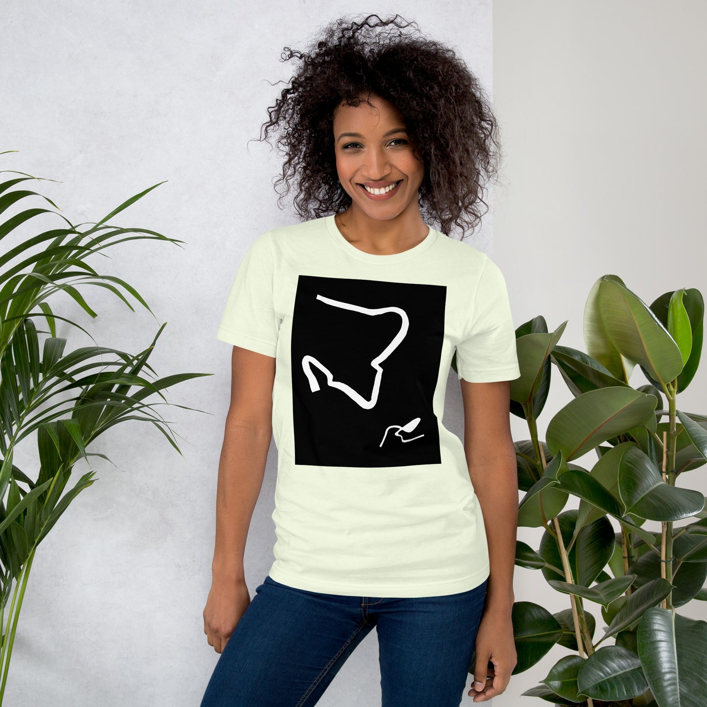 Woman wearing a citron color cotton graphic t-shirt with black and white abstract artwork of lines resembling a paperclip on fron