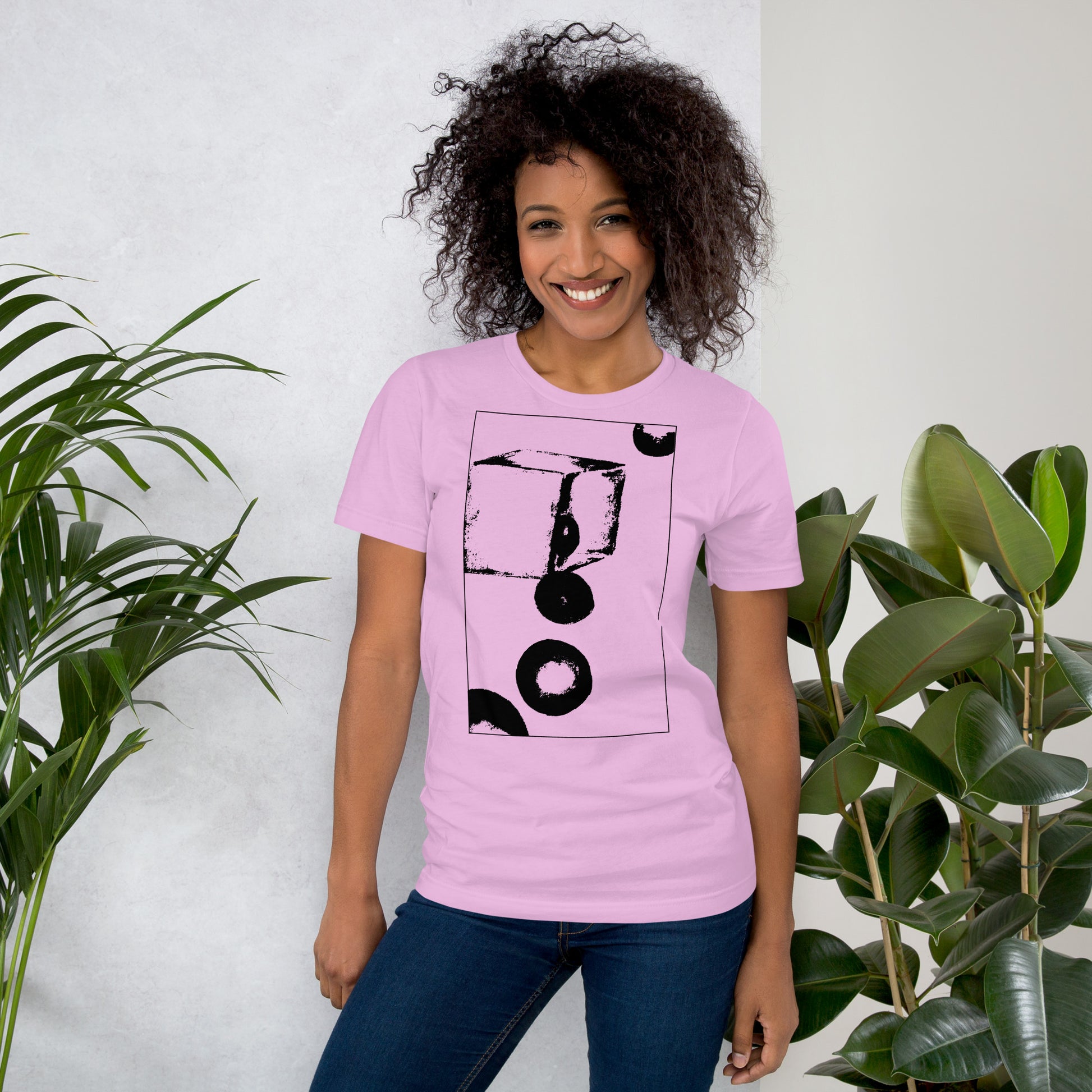 Woman wearing pink cotton graphic t-shirt with black abstract cube and spheres artwork in a thin black square on front