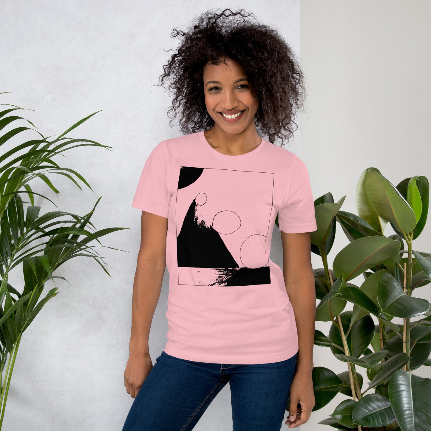 Woman wearing coral cotton graphic t-shirt with black abstract pyramid artwork in a thin black square on front